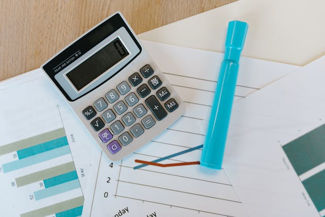 a calculator and highlighter on top of financial documents