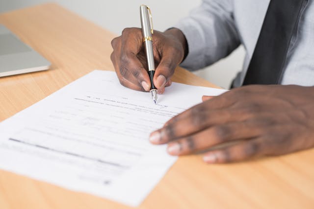 a person using a silver pen signing a lease